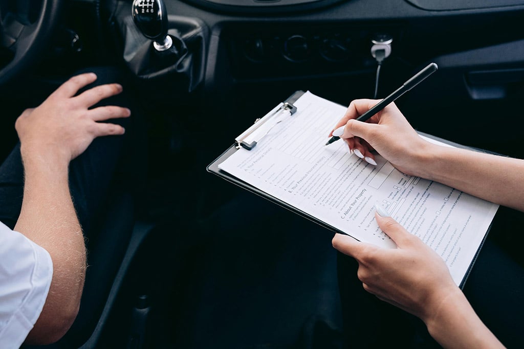Une femme en train de compléter un contrat d’assurance automobile